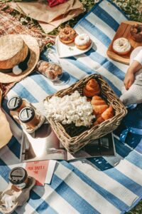 picnic-on-blue-and-white-blanket-with-straw-hat-and-basket-of-food