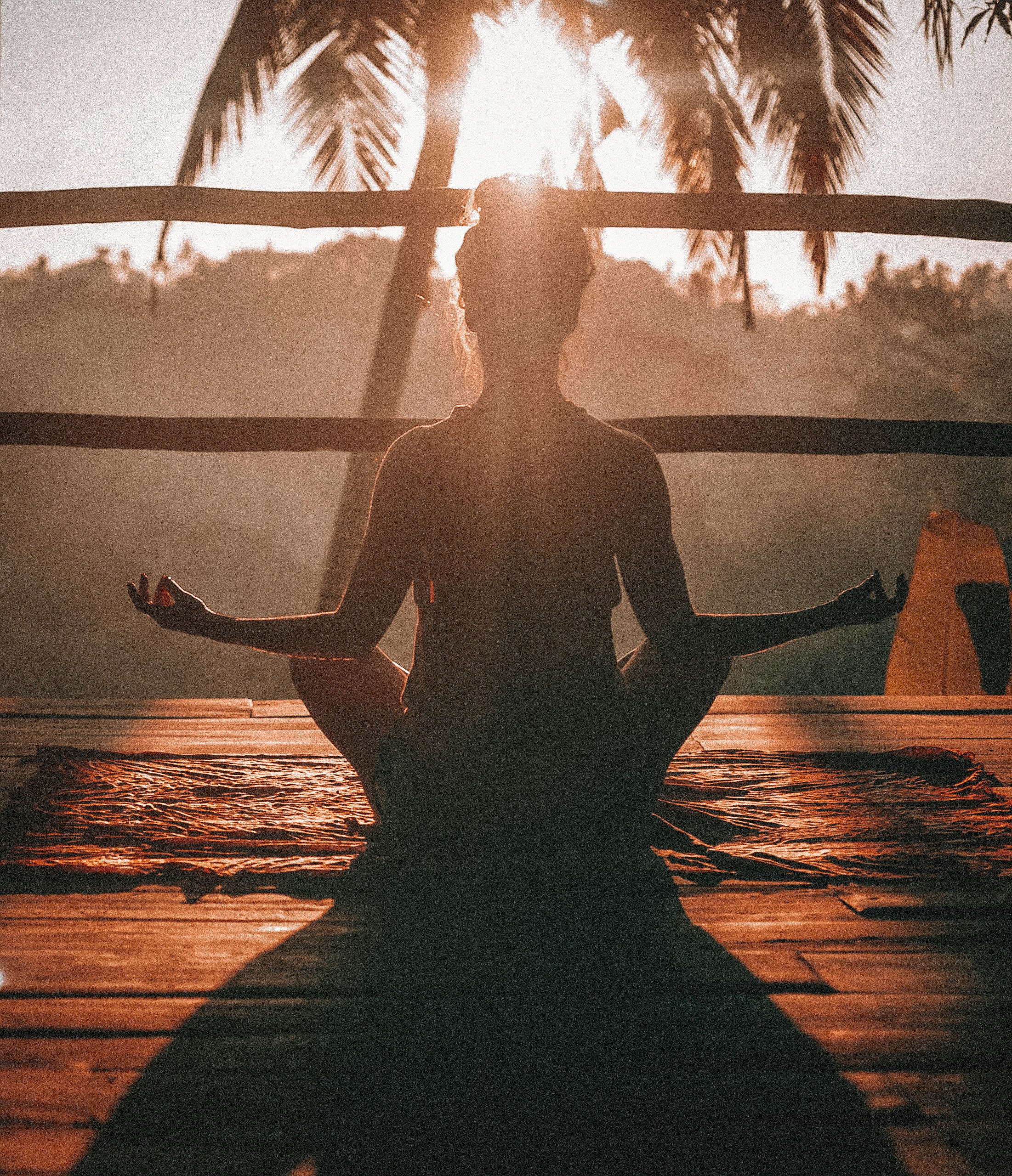 dark-figure-of-the-back-of-a-woman-meditating-in-sunny-balcony