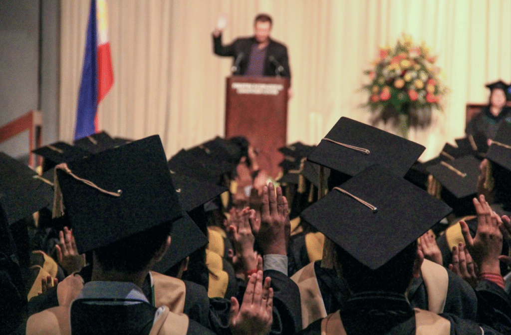 speaker-at-podium-in-front-of-graduating-students-in-caps