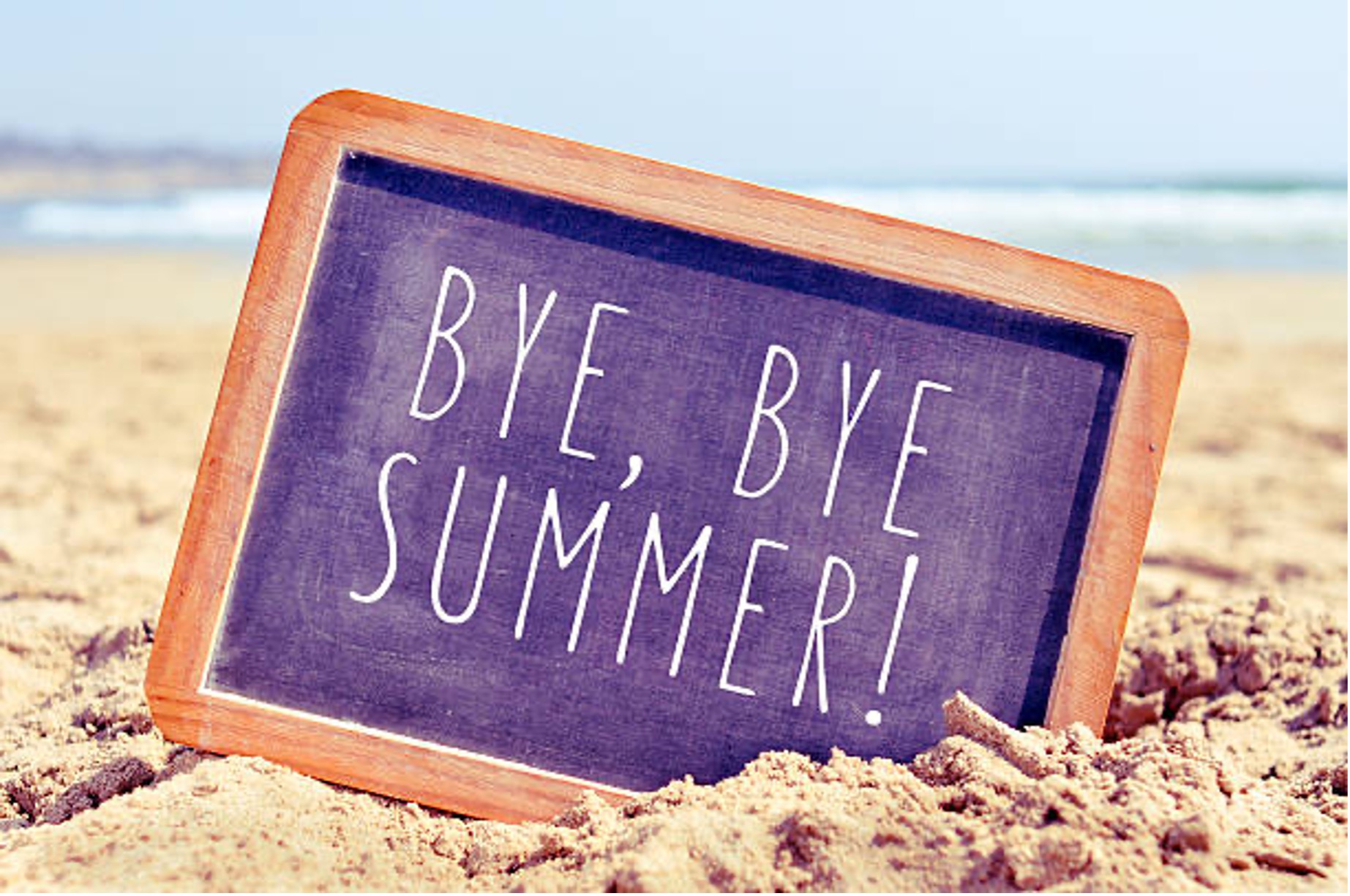 chalkboard-sign-with-bye-bye-summer-text-in-sand-on-beach