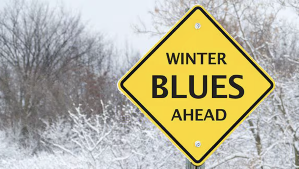 caution sign with winter blues ahead in text