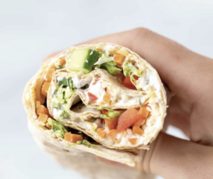 wrap filled with tomatoes, cucumber, and sauce