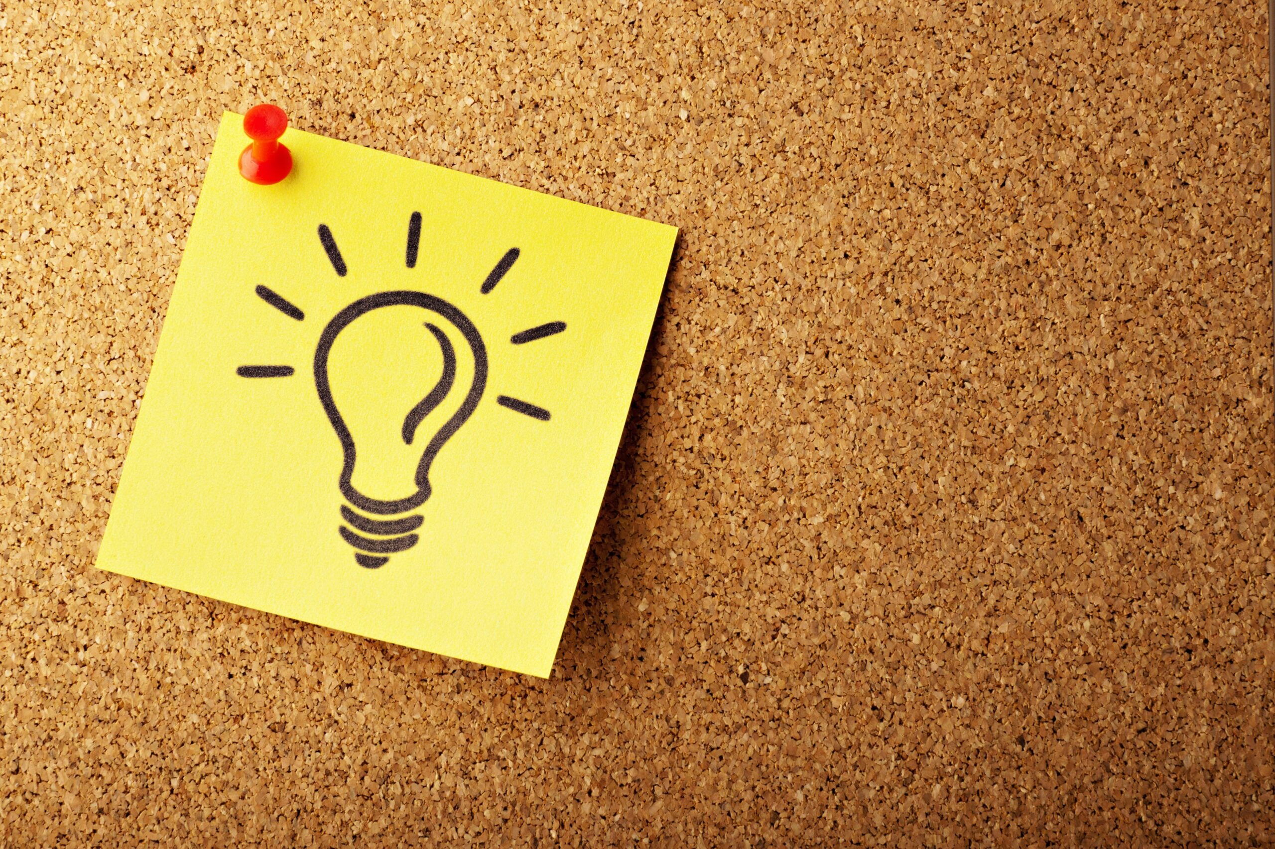 drawing of light bulb on sticky note pinned to wall