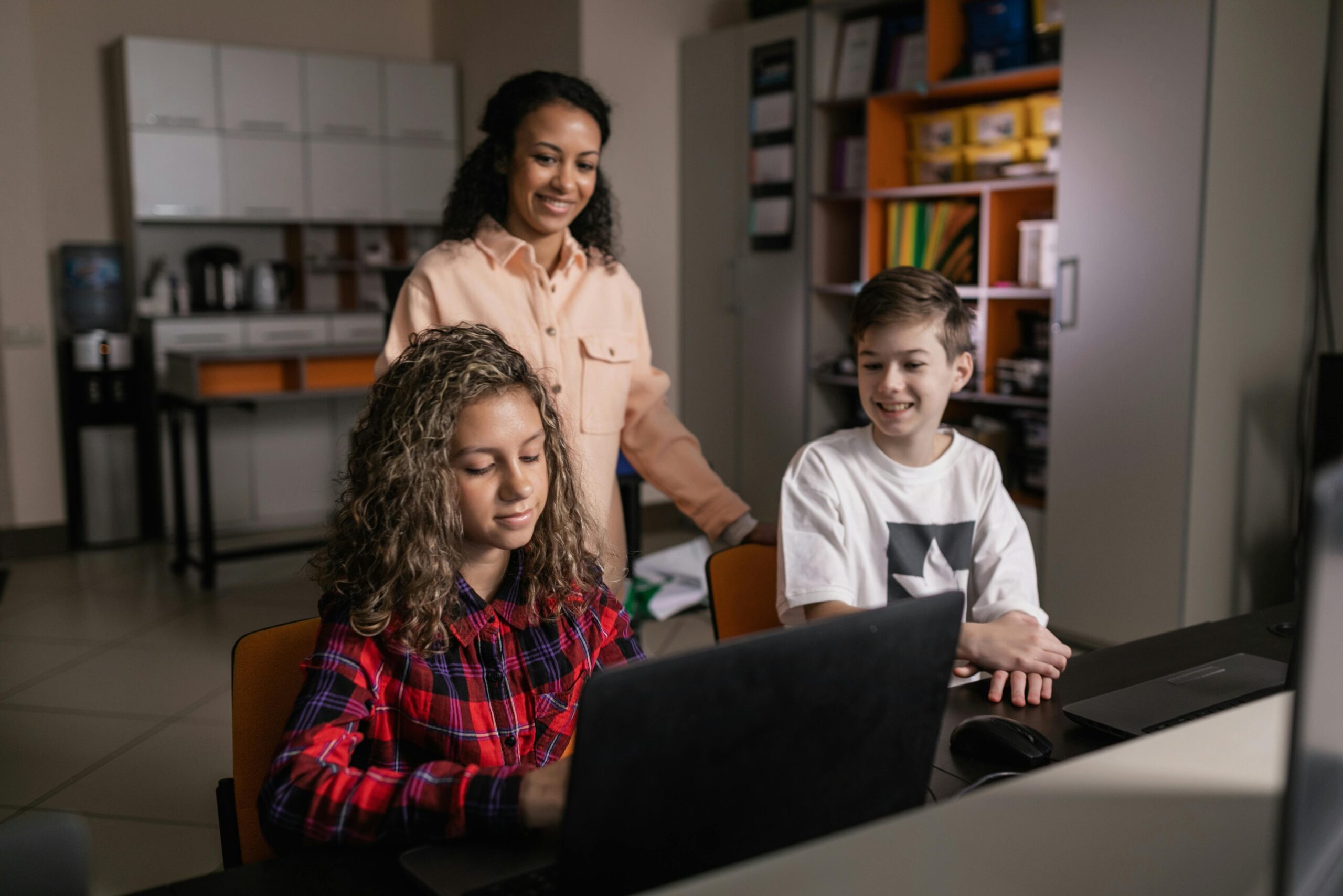 teacher with kids on laptops using AI