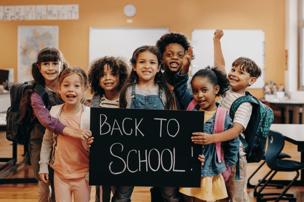children-in-classroom-with-back-to-school-written-in-chalk