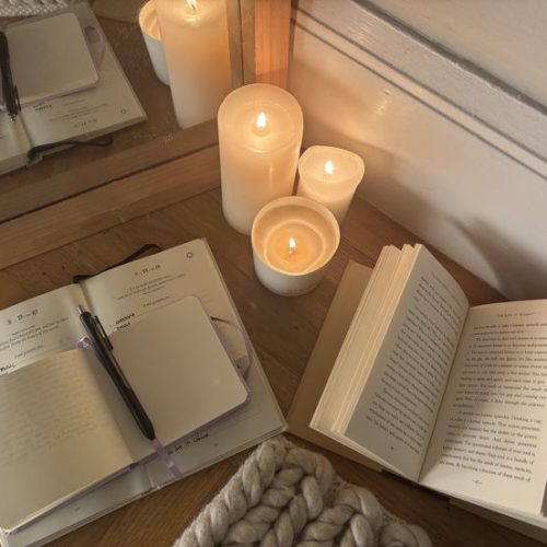 open books and candles on wooden table