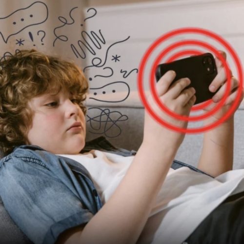 kid lying down holding electronic device
