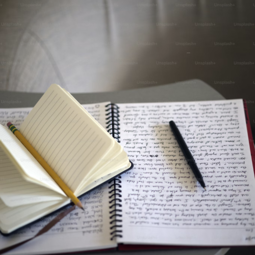 open notebooks with writing and pencils