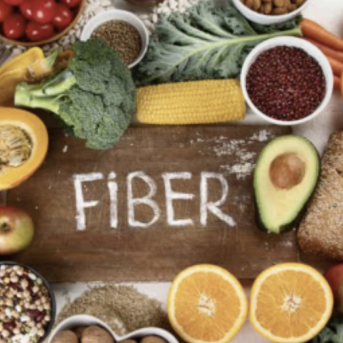 fruits and green vegetables surrounding the word FIBER on wood