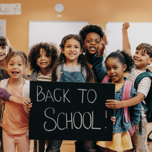 children-in-classroom-with-back-to-school-written-in-chalk
