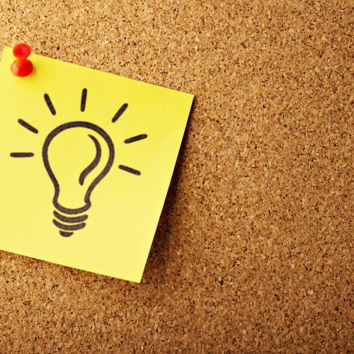 drawing of light bulb on sticky note pinned to wall