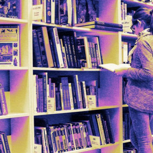 man-standing-before-bookstore-shelves
